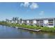 Waterfront condo building featuring a private dock and lush landscaping with stunning river views at 1401 S Mccall Rd # 205, Englewood, FL 34223