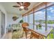 Enclosed lanai with wicker seating, ceiling fan, and beautiful water views at 1401 S Mccall Rd # 205, Englewood, FL 34223