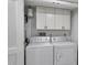 Functional laundry room with modern washer and dryer, storage cabinets, and good lighting at 1401 S Mccall Rd # 205, Englewood, FL 34223