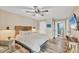 Bright main bedroom with a decorative headboard, a flatscreen TV, and an en-suite bathroom at 1401 S Mccall Rd # 205, Englewood, FL 34223