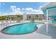 Community pool and building surrounded by lounge chairs and trees at 1401 S Mccall Rd # 205, Englewood, FL 34223