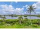 Picturesque water view featuring lush greenery, palm trees, and blue skies at 1401 S Mccall Rd # 205, Englewood, FL 34223