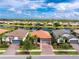 Aerial view of homes in a waterside community featuring tile roofs, and lush landscaping at 1530 Hyssop Loop, North Port, FL 34289