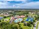 Breathtaking aerial view featuring the community's clubhouse, pool, tennis courts, and beautiful landscaping at 1530 Hyssop Loop, North Port, FL 34289