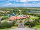 Stunning aerial shot of the community's pool, tennis courts, clubhouse, and green spaces under a blue sky at 1530 Hyssop Loop, North Port, FL 34289