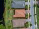 Overhead view of house showcasing its tile roof, brick driveway, and lush backyard facing the lake at 1530 Hyssop Loop, North Port, FL 34289