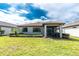 Landscaped backyard with a screened-in patio and green grass at 1530 Hyssop Loop, North Port, FL 34289