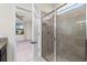 Bathroom shower featuring glass doors, a stone tiled interior, and shower head with hose at 1530 Hyssop Loop, North Port, FL 34289