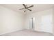 Spacious bedroom featuring a ceiling fan, neutral carpeting, and a doorway at 1530 Hyssop Loop, North Port, FL 34289