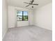 Carpeted bedroom with a large window that offers a view of palm trees outside at 1530 Hyssop Loop, North Port, FL 34289