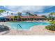 Relaxing community pool with ample seating, palm trees, and beautiful clubhouse at 1530 Hyssop Loop, North Port, FL 34289