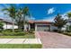 Charming single-story home with a tile roof, brick driveway, and mature landscaping at 1530 Hyssop Loop, North Port, FL 34289