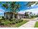 Attractive home featuring palm trees, well-maintained landscaping, and a paved driveway leading to the garage at 1530 Hyssop Loop, North Port, FL 34289