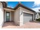 Home exterior showcasing the front door, brick driveway, and a two-car garage at 1530 Hyssop Loop, North Port, FL 34289