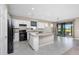 Bright kitchen features white cabinets, black appliances, granite countertops, and a kitchen island overlooking the lanai at 1530 Hyssop Loop, North Port, FL 34289