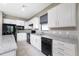 Kitchen features white cabinetry, black appliances, granite countertops, and stainless steel sink at 1530 Hyssop Loop, North Port, FL 34289