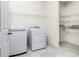 Laundry room with washer, dryer, tile floors, and white wire storage shelving at 1530 Hyssop Loop, North Port, FL 34289