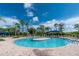 Beautiful community pool area featuring a central island, comfortable lounge chairs, and clear blue skies at 1530 Hyssop Loop, North Port, FL 34289