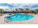 Large community pool with lounge chairs, palm trees, and a beautiful clubhouse, ideal for outdoor recreation at 1530 Hyssop Loop, North Port, FL 34289