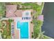 Aerial view of pool, hot tub and dock overlooking the lake, surrounded by palm trees and lush landscaping at 2004 Longpointe Cir # E2, Venice, FL 34293