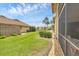 Well-maintained backyard with lush green lawn, manicured bushes, and a screened patio, perfect for outdoor relaxation at 2004 Longpointe Cir # E2, Venice, FL 34293