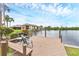 Serene waterfront with wooden dock offering seating to enjoy the tranquil lake views and the surrounding community at 2004 Longpointe Cir # E2, Venice, FL 34293