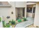 A well-kept front entrance features charming decor, plants, and a covered patio beyond sliding glass doors at 2004 Longpointe Cir # E2, Venice, FL 34293