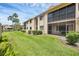 Well-maintained condo exterior features a screened lanai, lush landscaping, and a manicured lawn, offering serene outdoor living at 2004 Longpointe Cir # E2, Venice, FL 34293