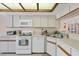 Fully equipped kitchen with white cabinets and modern appliances at 2004 Longpointe Cir # E2, Venice, FL 34293