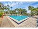 Community pool featuring lounge chairs and tropical landscaping, inviting residents to unwind and enjoy the outdoors at 2004 Longpointe Cir # E2, Venice, FL 34293