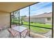 Inviting screened porch with outdoor seating and scenic views of the landscaped yard and blue sky at 2004 Longpointe Cir # E2, Venice, FL 34293