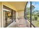 Charming screened porch with patio furniture, offering a peaceful outdoor retreat with lush green surroundings at 2004 Longpointe Cir # E2, Venice, FL 34293