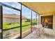 Relaxing screened porch with views of green lawn, landscaping, and nearby buildings in a serene setting at 2004 Longpointe Cir # E2, Venice, FL 34293