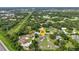 Aerial view showcasing a home with solar panels, screened-in pool, patio, and surrounding greenery at 2541 Northway Dr, Venice, FL 34292