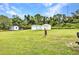 Expansive backyard features multiple storage sheds and a large grassy area at 2541 Northway Dr, Venice, FL 34292