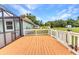 Wooden deck features white railings with a screen room and landscaped backyard at 2541 Northway Dr, Venice, FL 34292