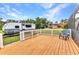 Wooden deck features white railings, a green lawn and a parked trailer in the background at 2541 Northway Dr, Venice, FL 34292