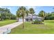 Inviting single-story home with a lush green lawn and mature palm trees at 2541 Northway Dr, Venice, FL 34292