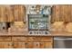 Kitchen area with a double sink, natural wood cabinets, and a view of the backyard pool at 2541 Northway Dr, Venice, FL 34292