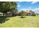 Spacious backyard featuring a screened-in patio, lush lawn, and mature trees offering shade at 27581 Tierra Del Fuego Cir, Punta Gorda, FL 33983