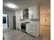 A modern kitchen is brightened with white cabinets, stainless steel appliances, and stone countertops at 4300 Avanti Cir, North Port, FL 34287