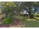 Expansive backyard featuring lush lawn, mature trees, and a charming shed for storage or hobbies at 7104 Castilla St, Port Charlotte, FL 33981