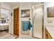 Bathroom area featuring tiled walls, wood cabinetry, a shower with a glass door, and an adjoining bedroom at 7104 Castilla St, Port Charlotte, FL 33981