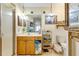Well-lit bathroom with a glass-enclosed shower, wood vanity, decorative mirror, and tiled flooring at 7104 Castilla St, Port Charlotte, FL 33981