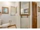 Bright bathroom with tiled walls, framed art, toilet, and a large mirror at 7104 Castilla St, Port Charlotte, FL 33981