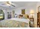 Comfortable bedroom with a ceiling fan, floral bedding, and a doorway leading to a lush backyard patio at 7104 Castilla St, Port Charlotte, FL 33981