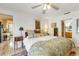 Inviting bedroom showcases a bed with floral bedding, a ceiling fan, and open access to the kitchen and bathroom at 7104 Castilla St, Port Charlotte, FL 33981