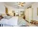 Bright bedroom featuring white walls, wood floors, and a ceiling fan, plus an elegant dresser and colorful bedspread at 7104 Castilla St, Port Charlotte, FL 33981