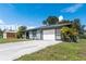 A ranch home with an attached garage and well-kept front lawn with mature palm trees at 7104 Castilla St, Port Charlotte, FL 33981