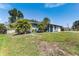 Charming home with lush landscaping, mature palm trees, and well-manicured lawn at 7104 Castilla St, Port Charlotte, FL 33981